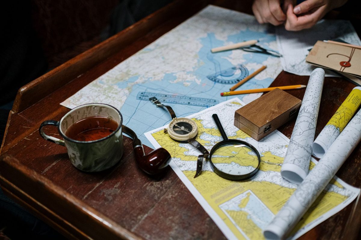 Nautical charts and a compass on a wooden table